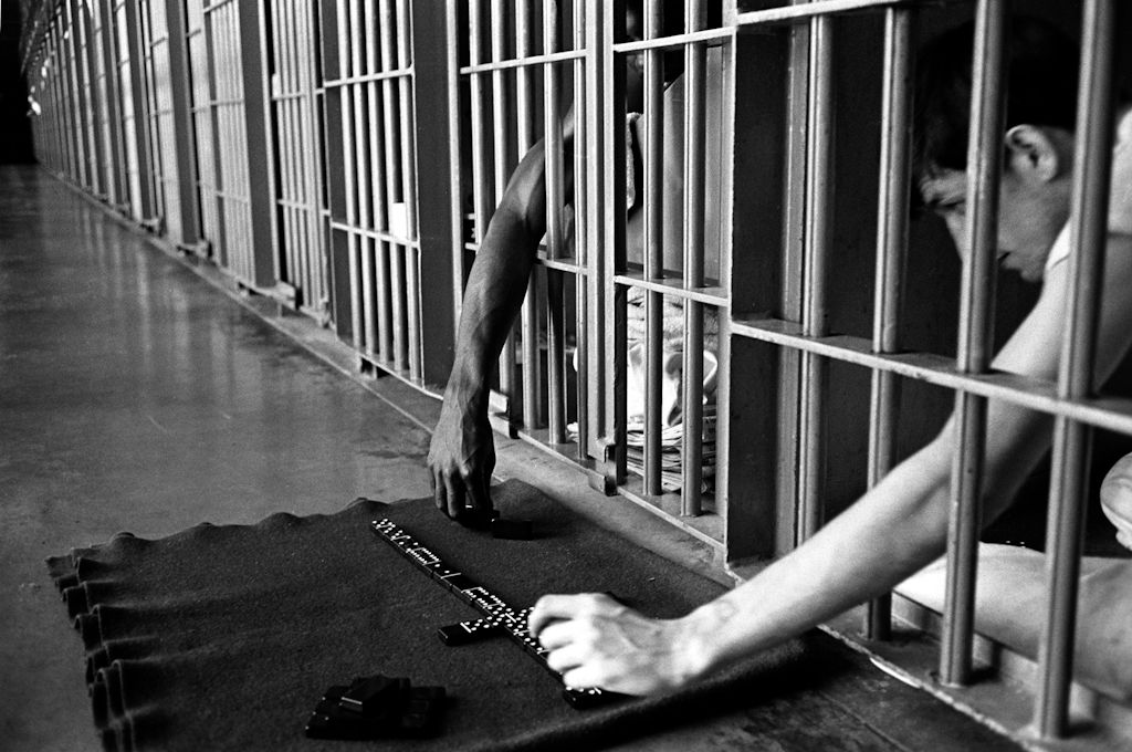 Playing dominoes from a single-man cell.
