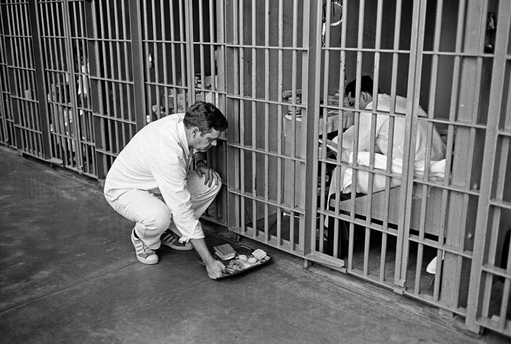 Ellis unit trustee Grigsby sliding food tray into cell.